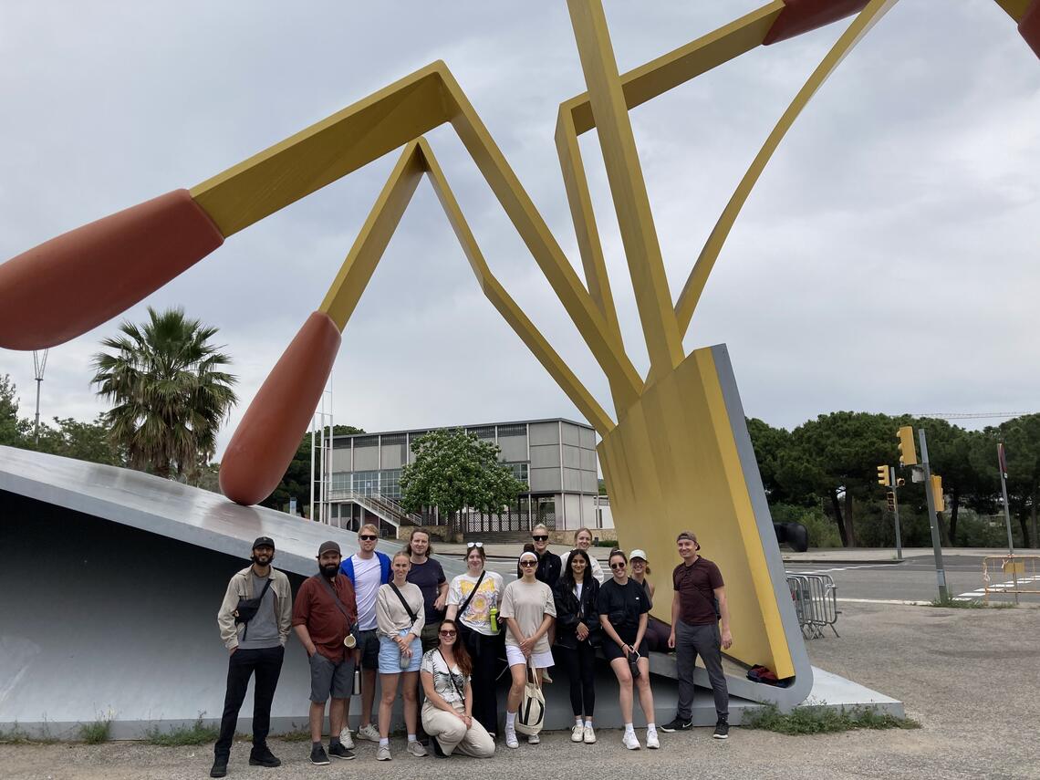 SAPL students pose in front of a yellow and red art installation in Barcelona
